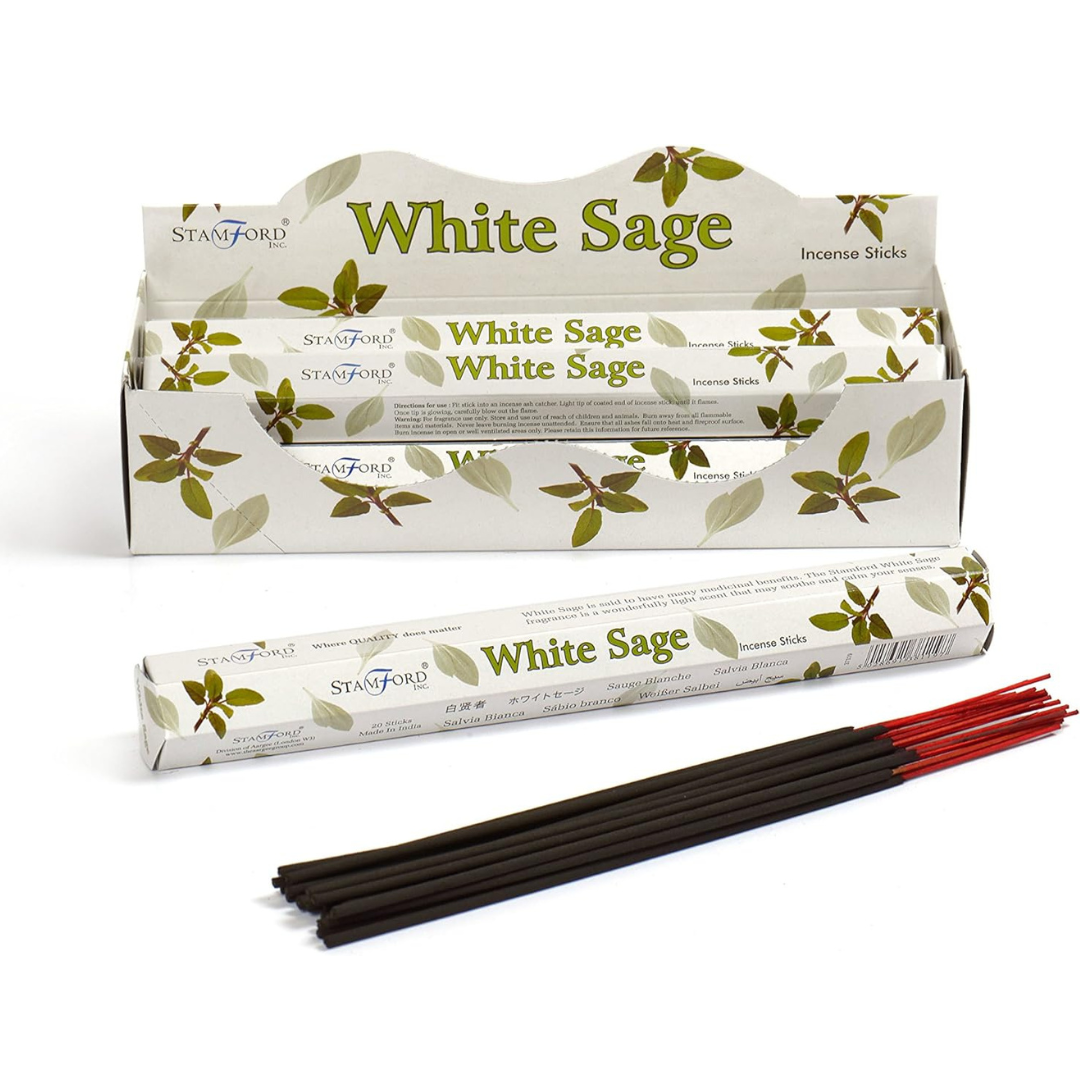 A box of Stamford White Sage incense sticks with several sticks visible in front, featuring green leaf designs on the packaging.