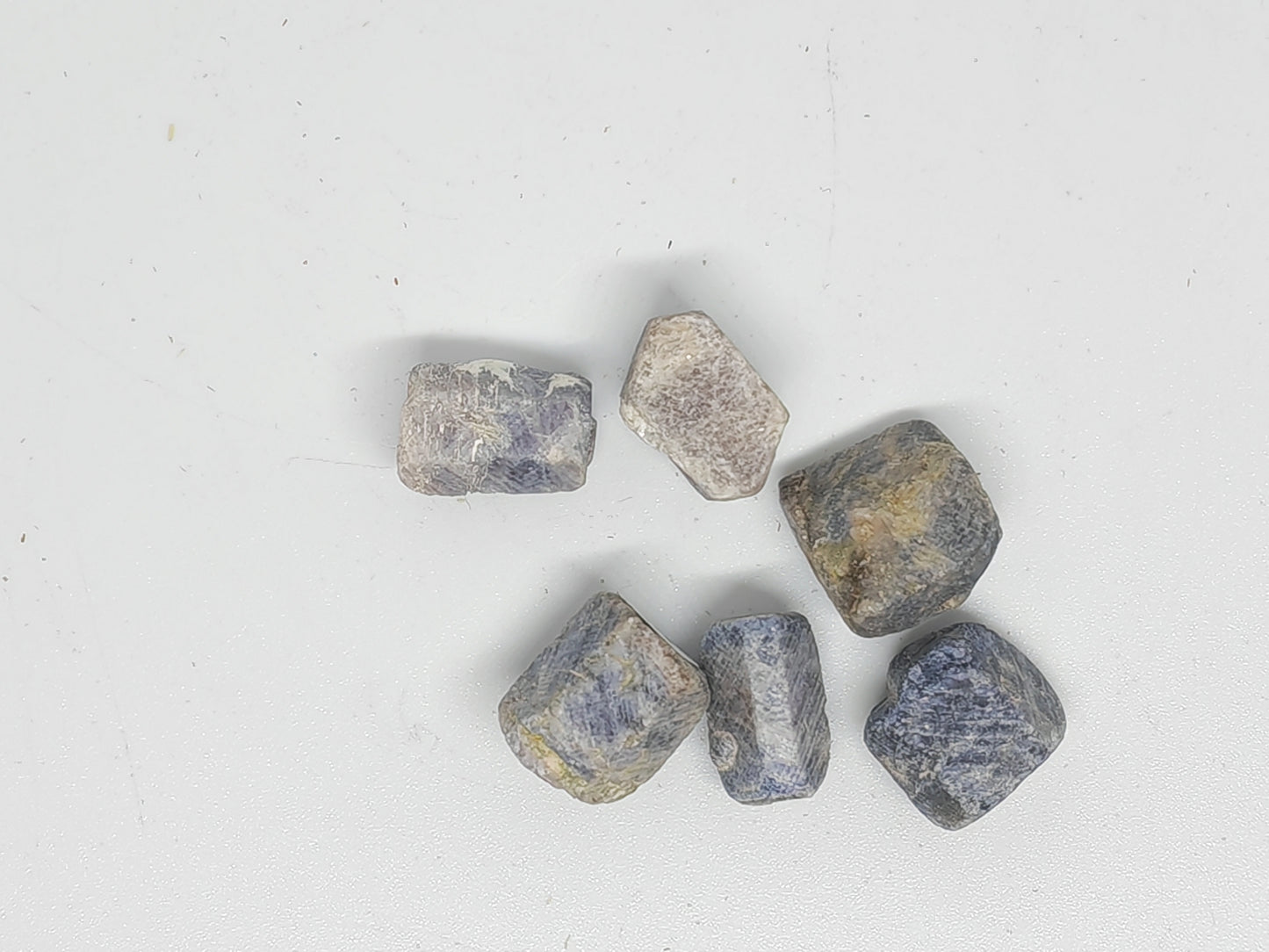 Raw gemstones on a light gray background