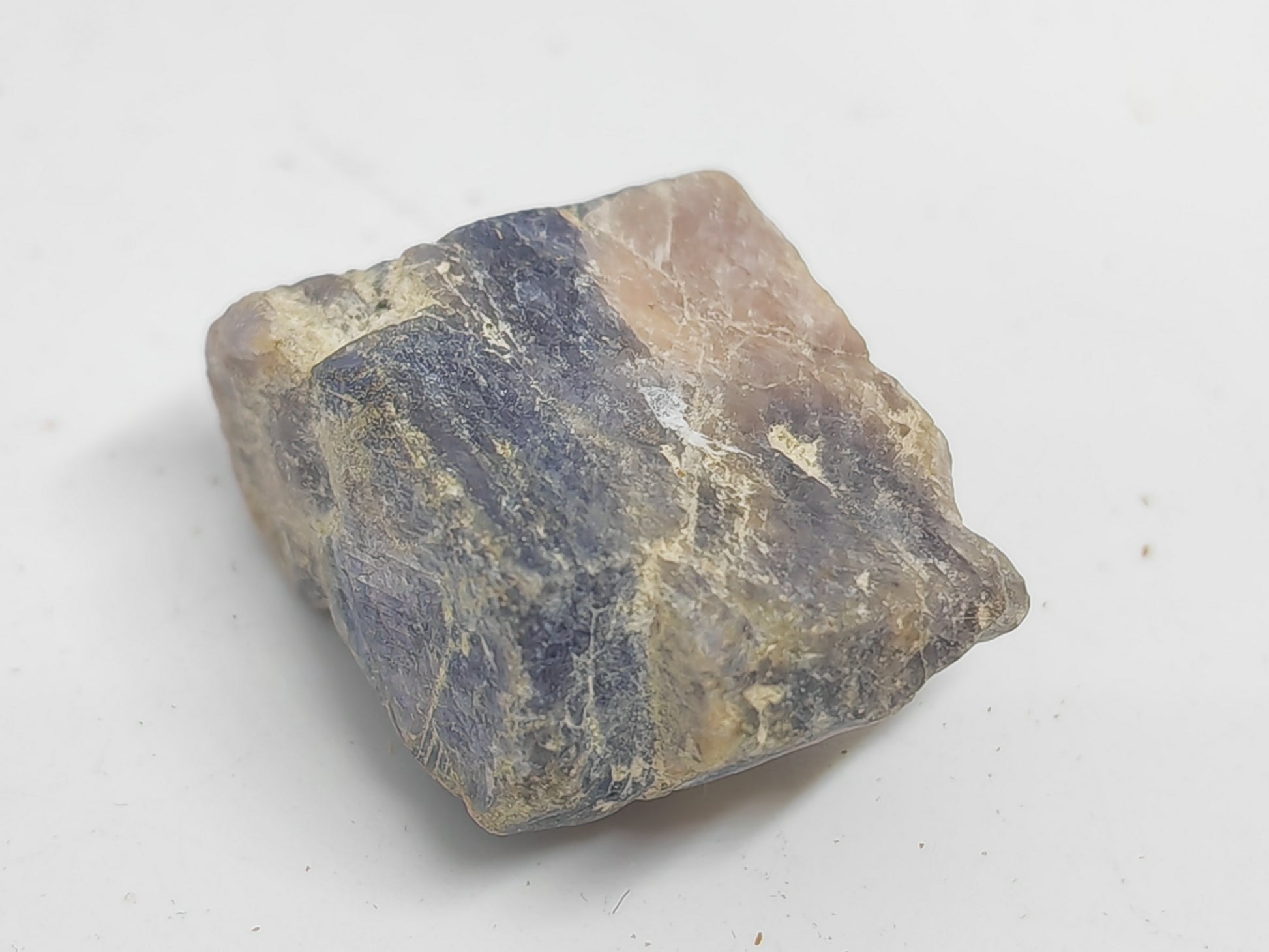 Raw stone with blue and brown hues on a white background