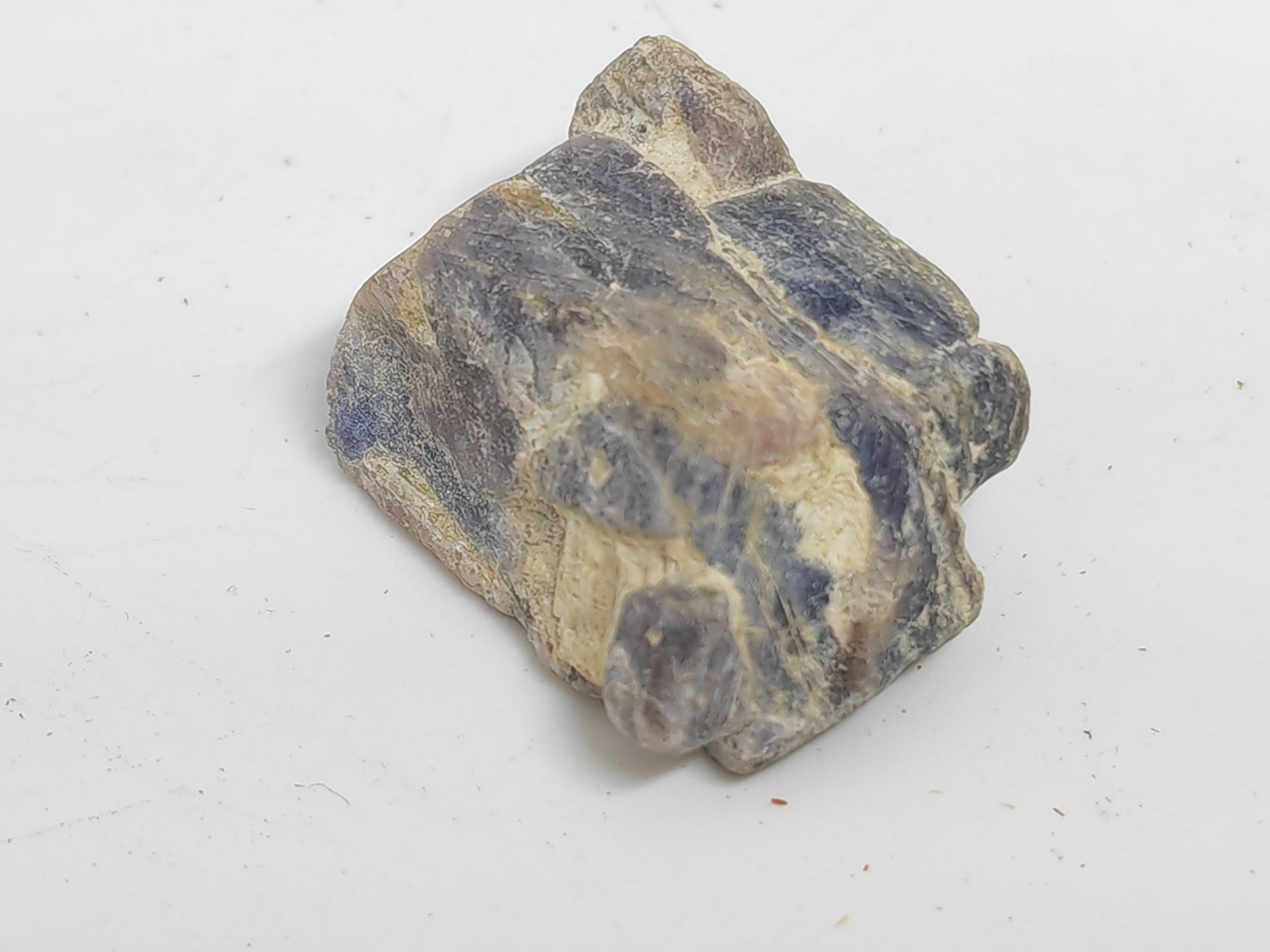 Fragment of a ceramic pot with blue and brown glaze on a white background