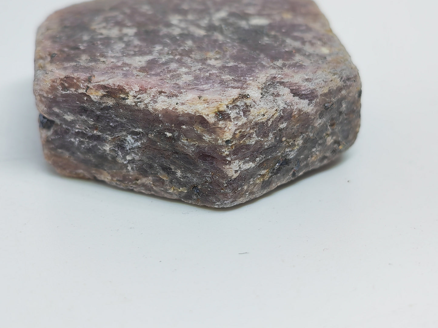 Close-up of a rough-textured stone on a light gray background