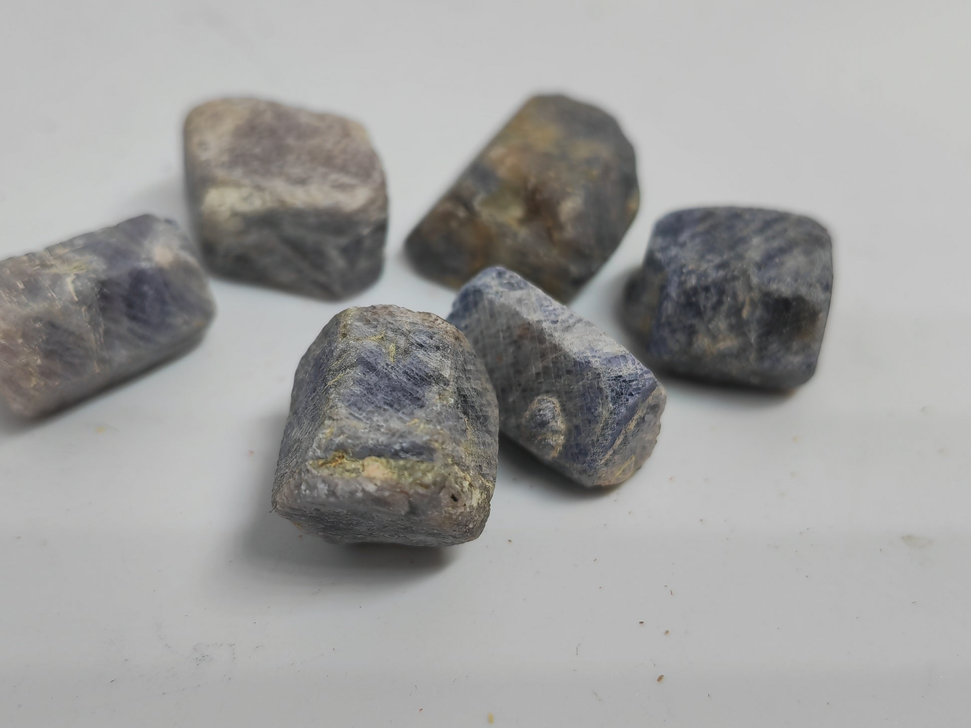 Raw sapphire stones on a light gray background