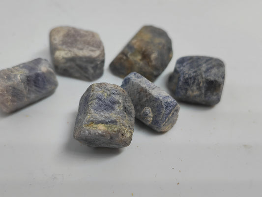 Raw sapphire stones on a light gray background