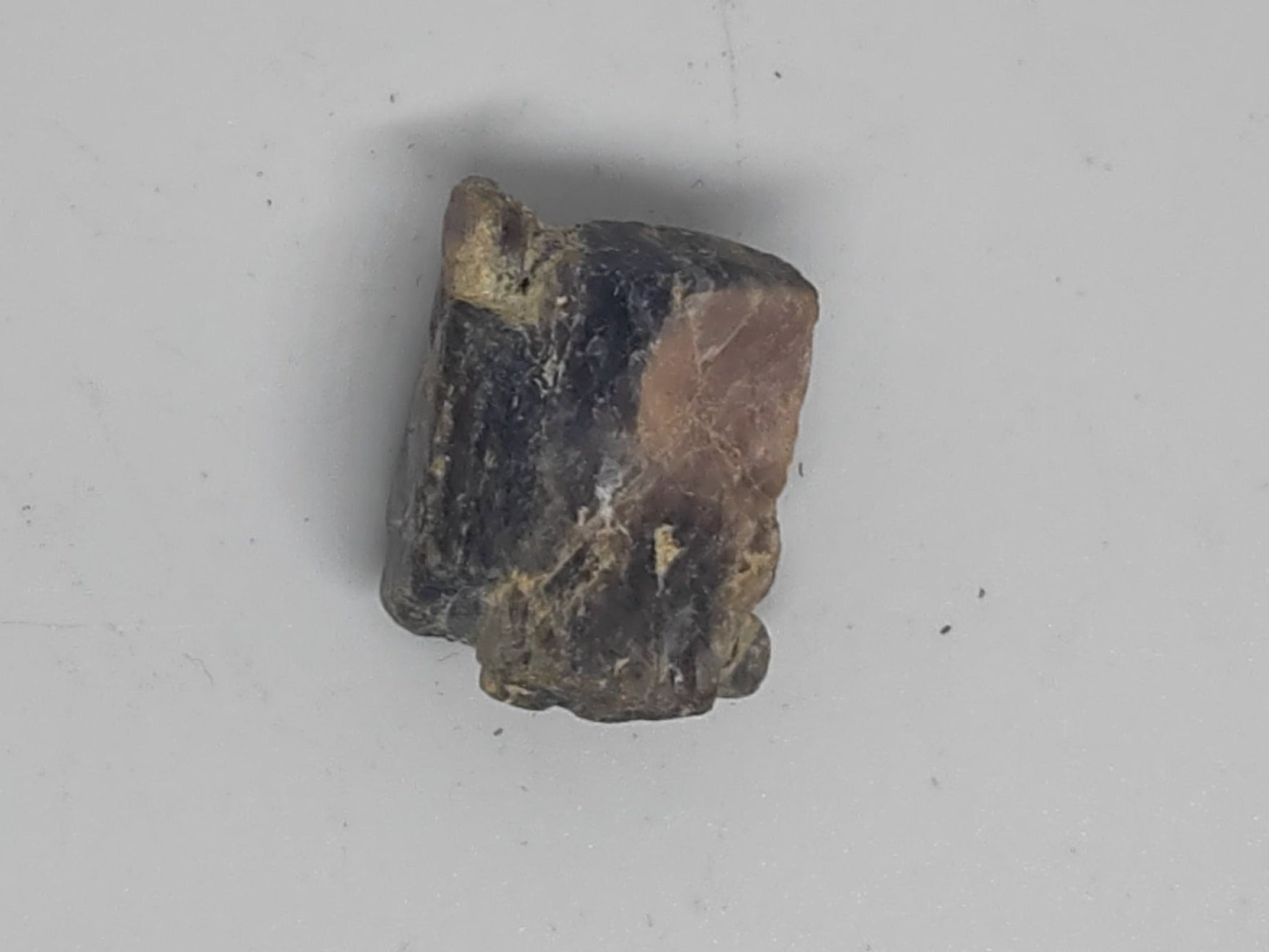 Small brown and black stone on a gray background